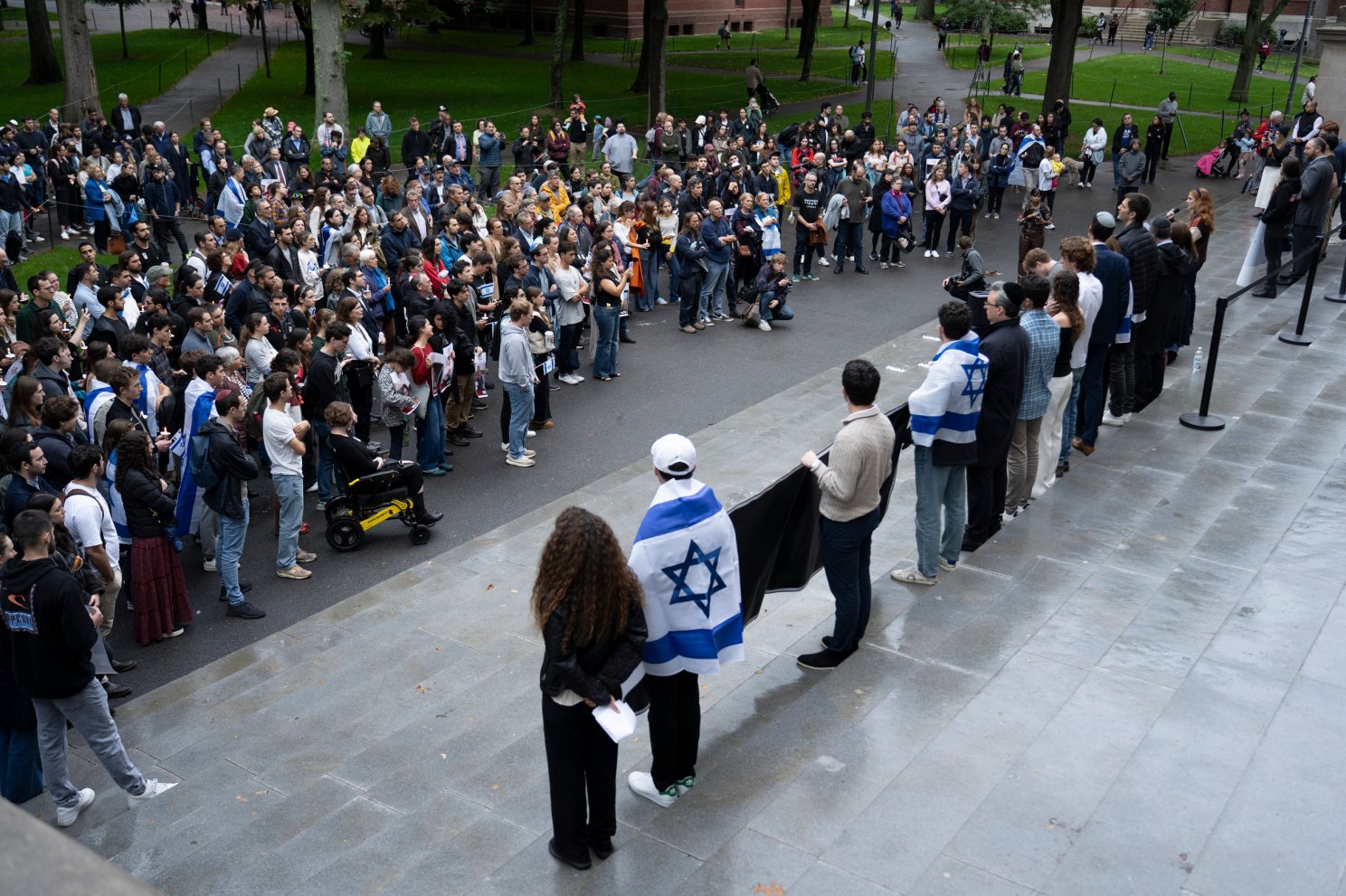 Harvard community members, some holding signs demanding to bring home the hostages.