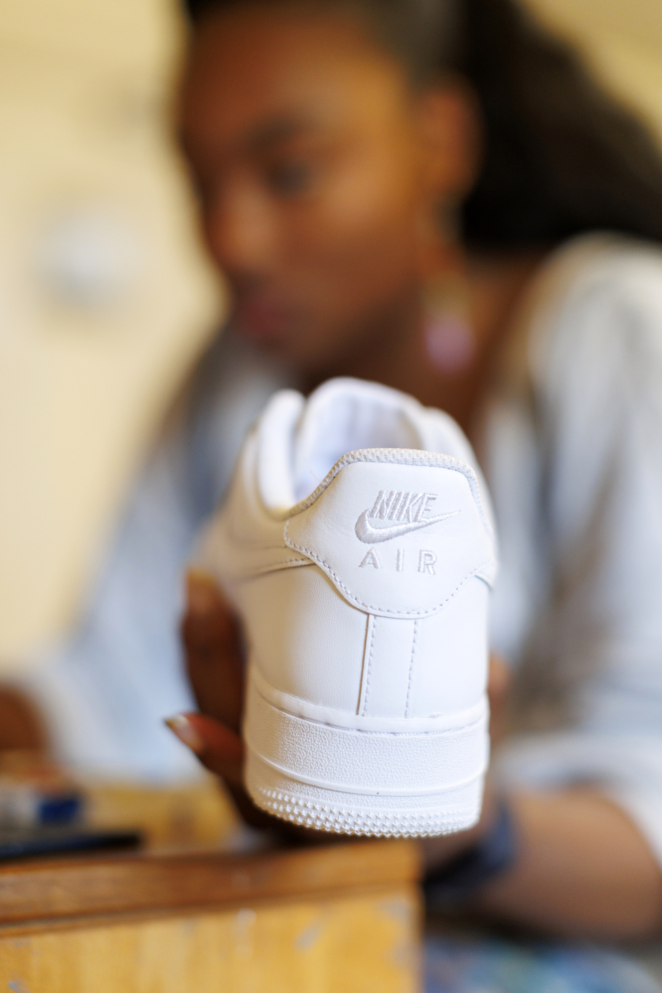 Gabby Anderson holding a new pair of blank shoes.