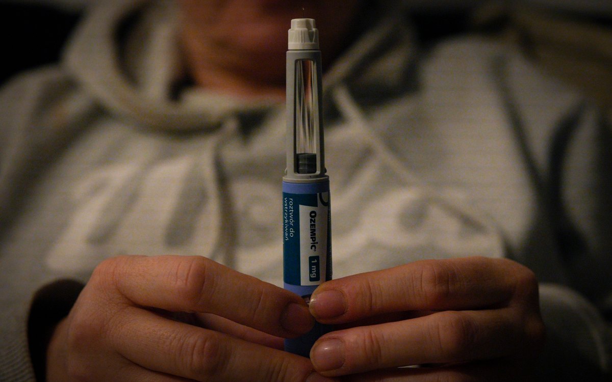 A woman holds an Ozempic needle shot pen.