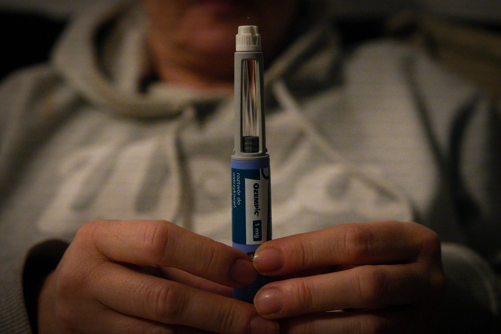 A woman holds an Ozempic needle shot pen.