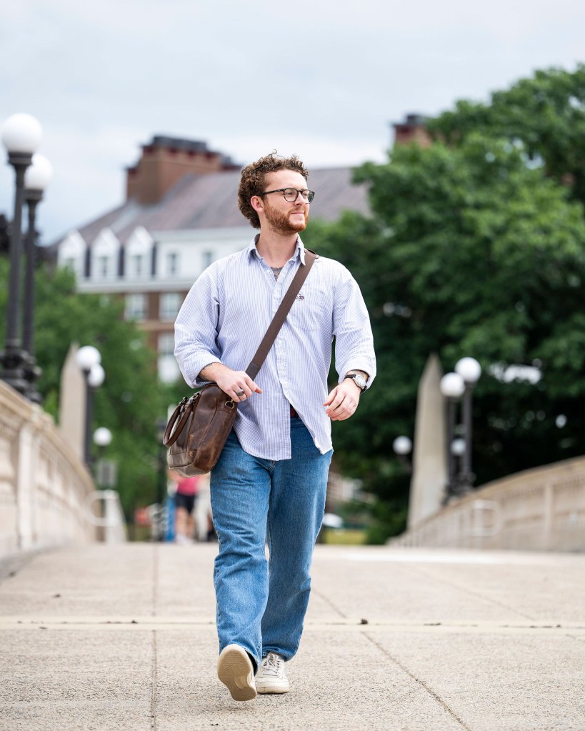 Harvard anthropology concentrator Shane Rice ’25 walking across Weeks Bridge.