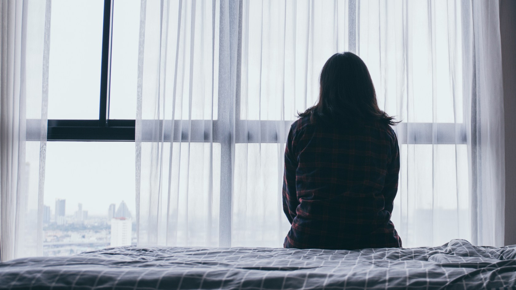 woman sitting on bed alone 