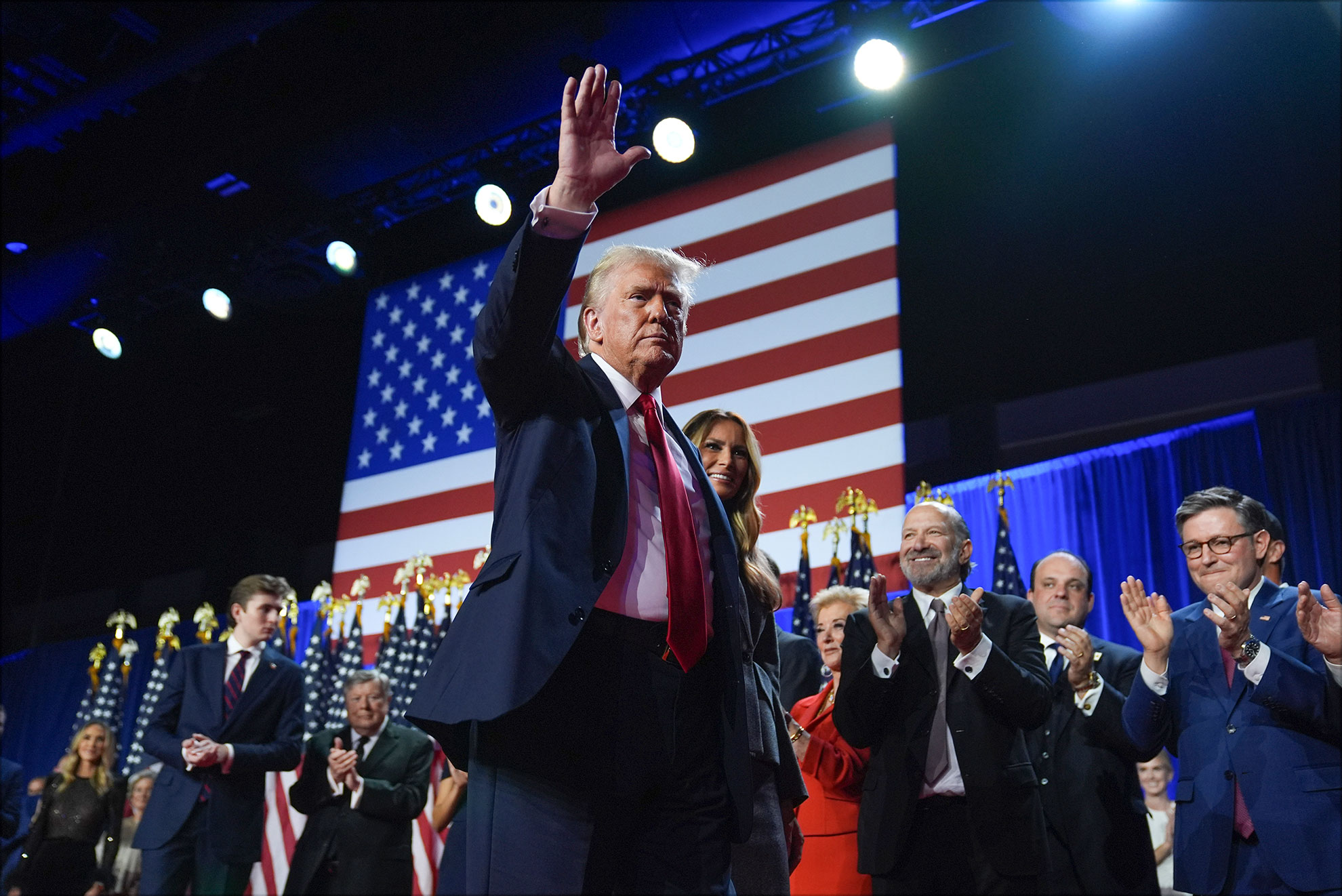 Republican presidential nominee former President Donald Trump waves as he walks with former first lady Melania Trump at an election night watch party.