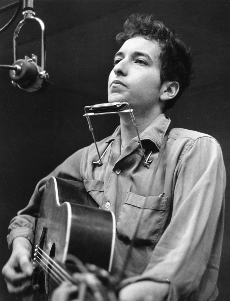 Bob Dylan with a harmonica and guitar