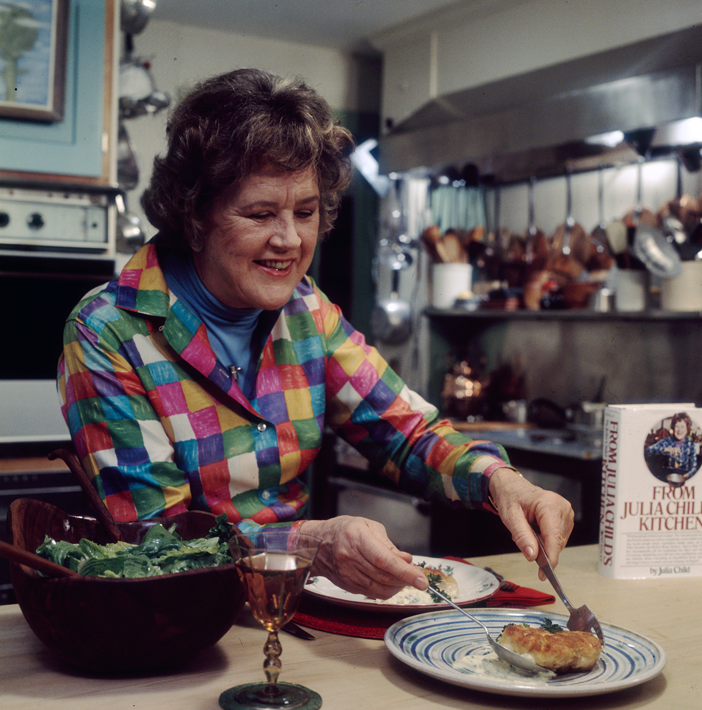 Julia Child serving food on a plate.