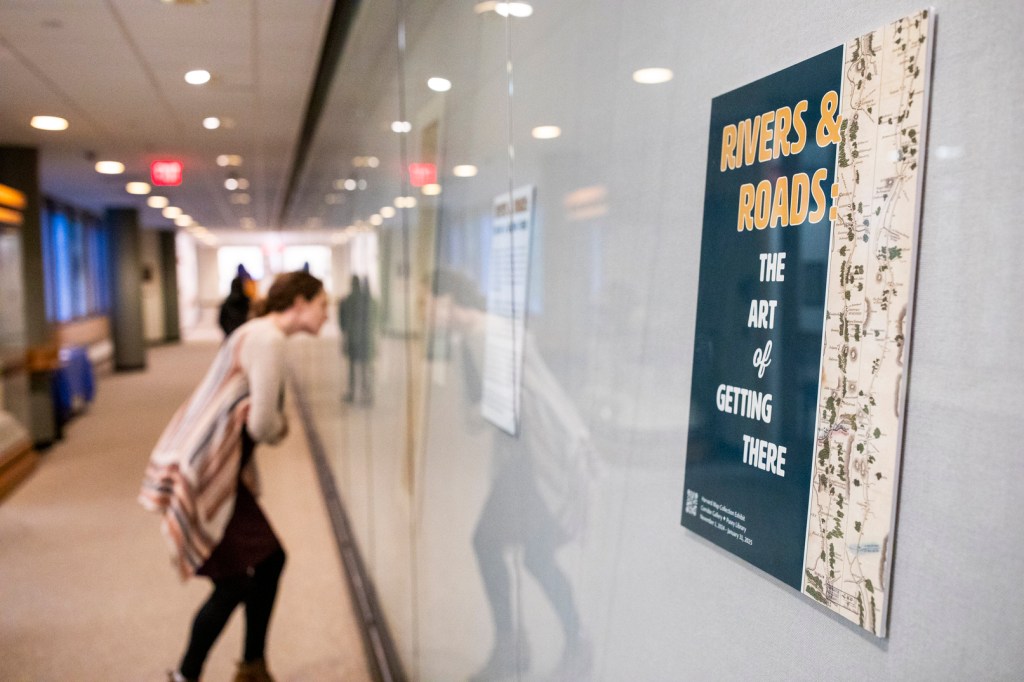 A visitor examines a map in the "Rivers & Roads" exhibit.