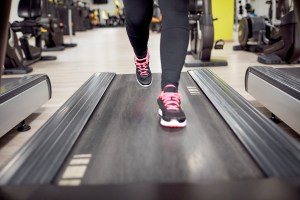 Detail of a person's legs on a treadmill in the gym.