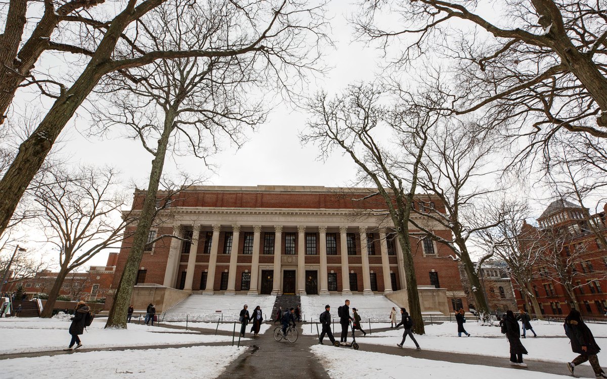 Students walk past Widener Library on their way to class through the freshly fallen snow.