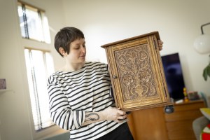 Eve Radovsky, Faculty Assistant at Harvard Law School, woodworker, and crafter poses for a photo with a cabinet she made.