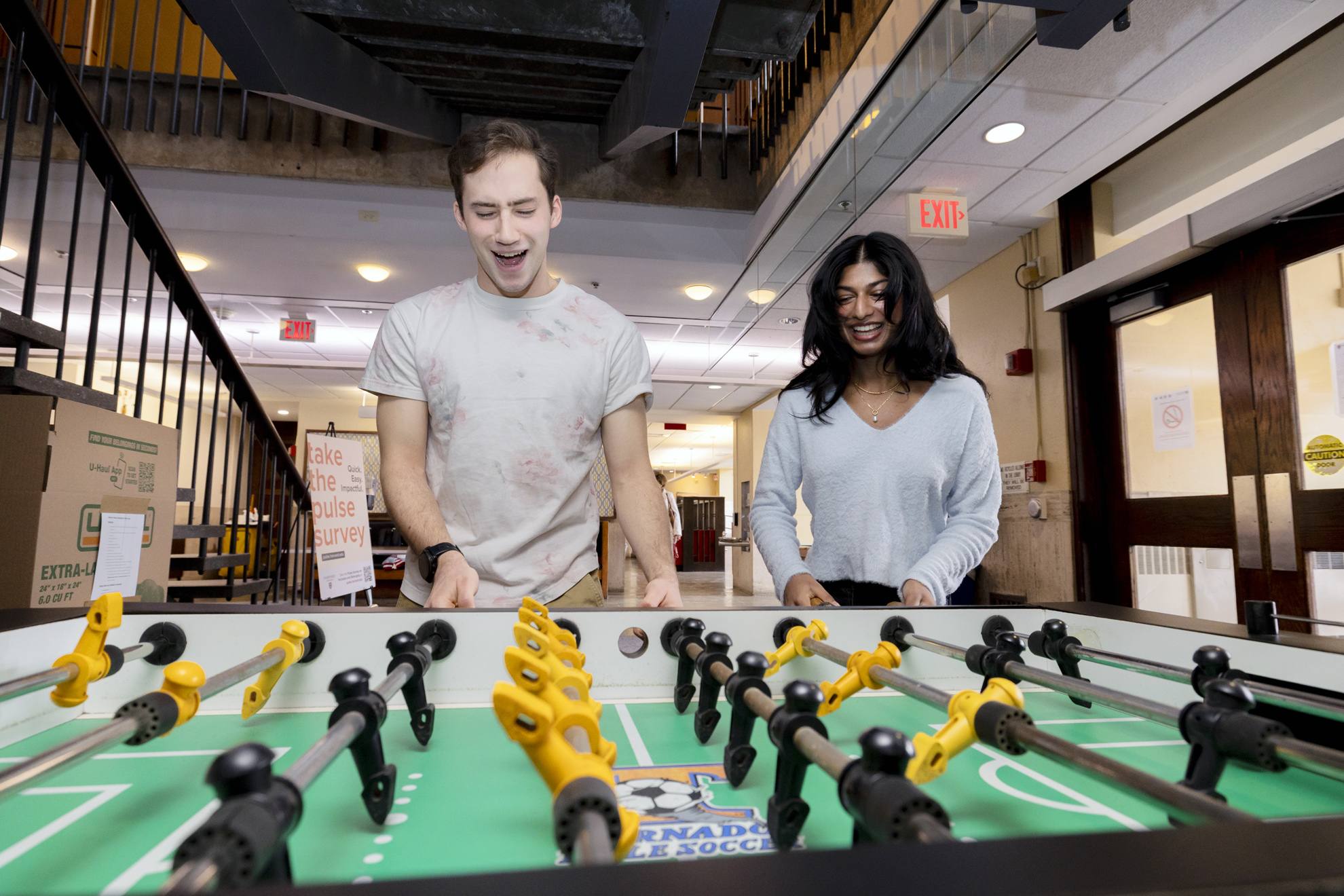 Emil Massad ’25 and Anoushka Chander ’25 play foosball in Quincy House.