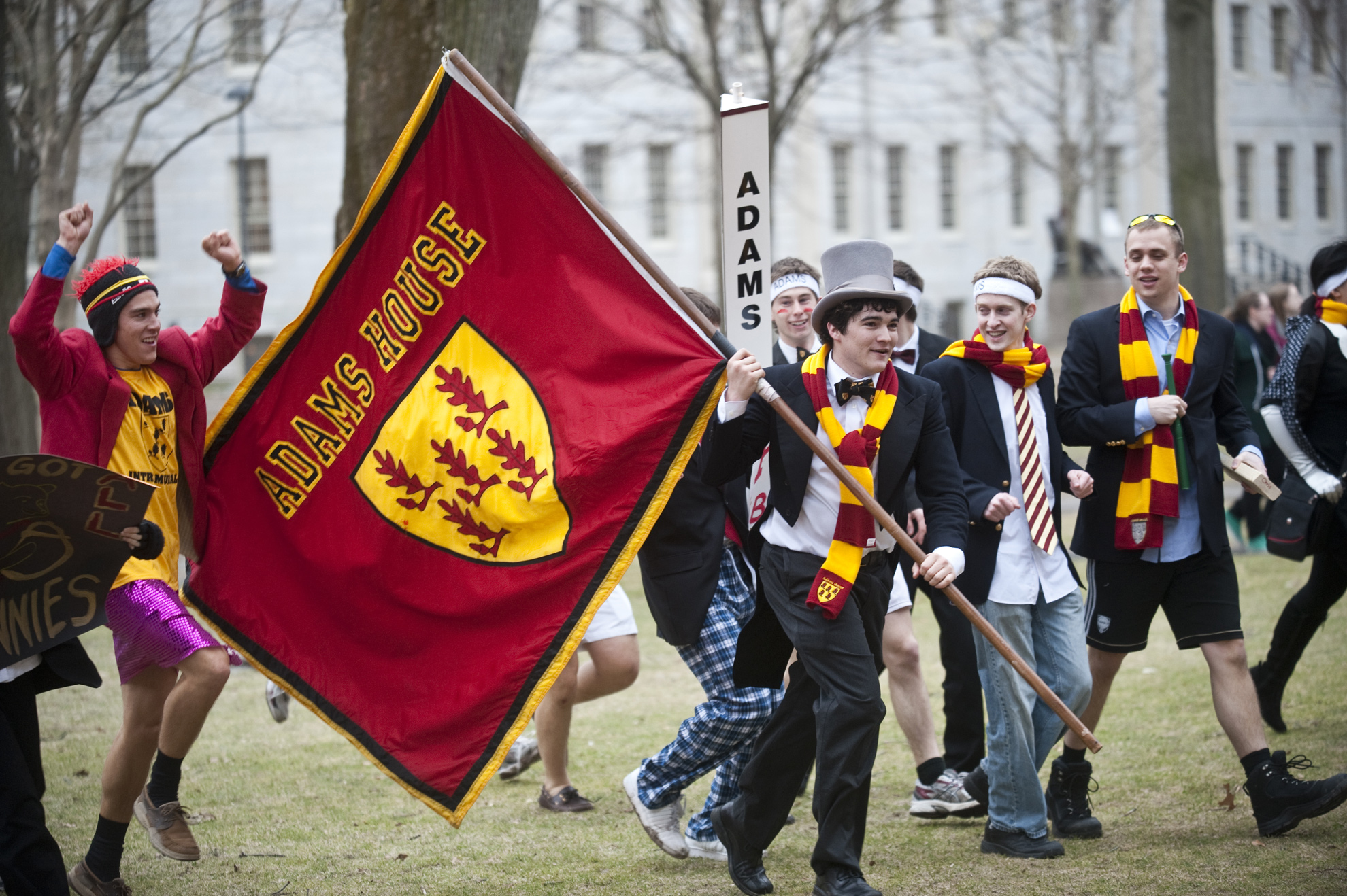 A contingent from Adams House including Antone Martinho carrying the banner makes its way across the Yard.