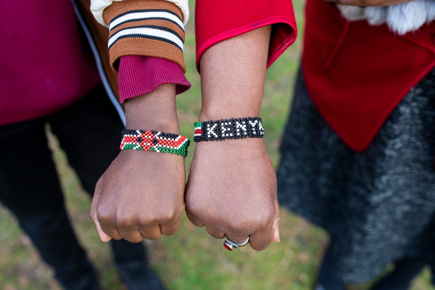 Emmanuel Enan Gachogu Muriuki (left), a first-year, and Sheila Thimba, Dean of Administration and Finance, display their Kenya bracelets in Harvard Yard. The two, both from Kenya