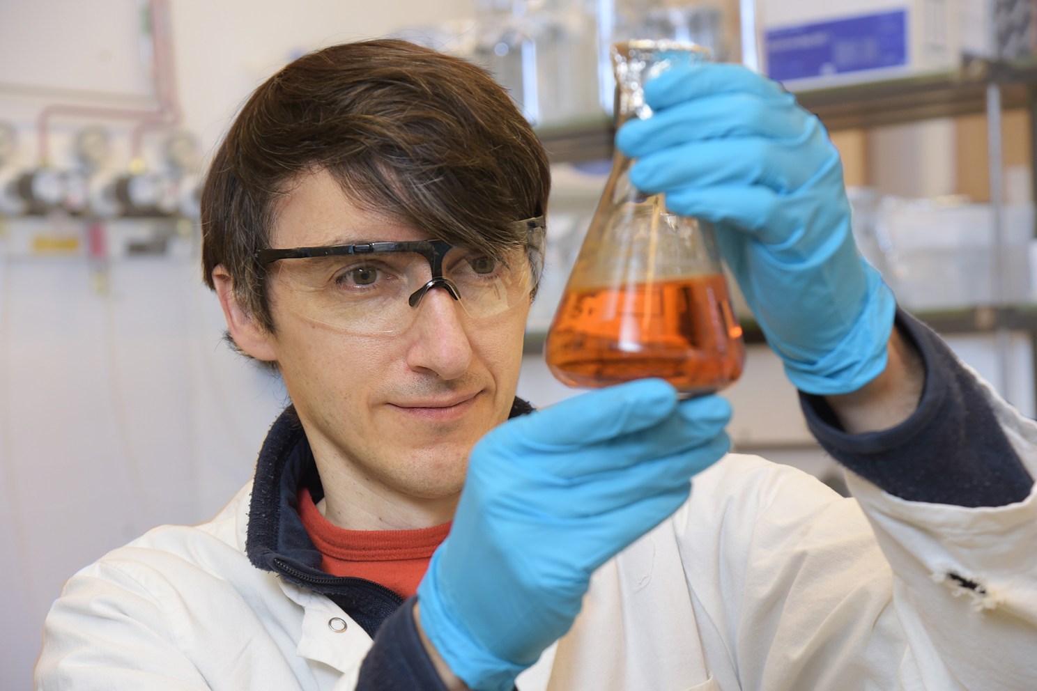 Felix Elling holds a flask containing an iron-oxidizing bacterium in his lab.