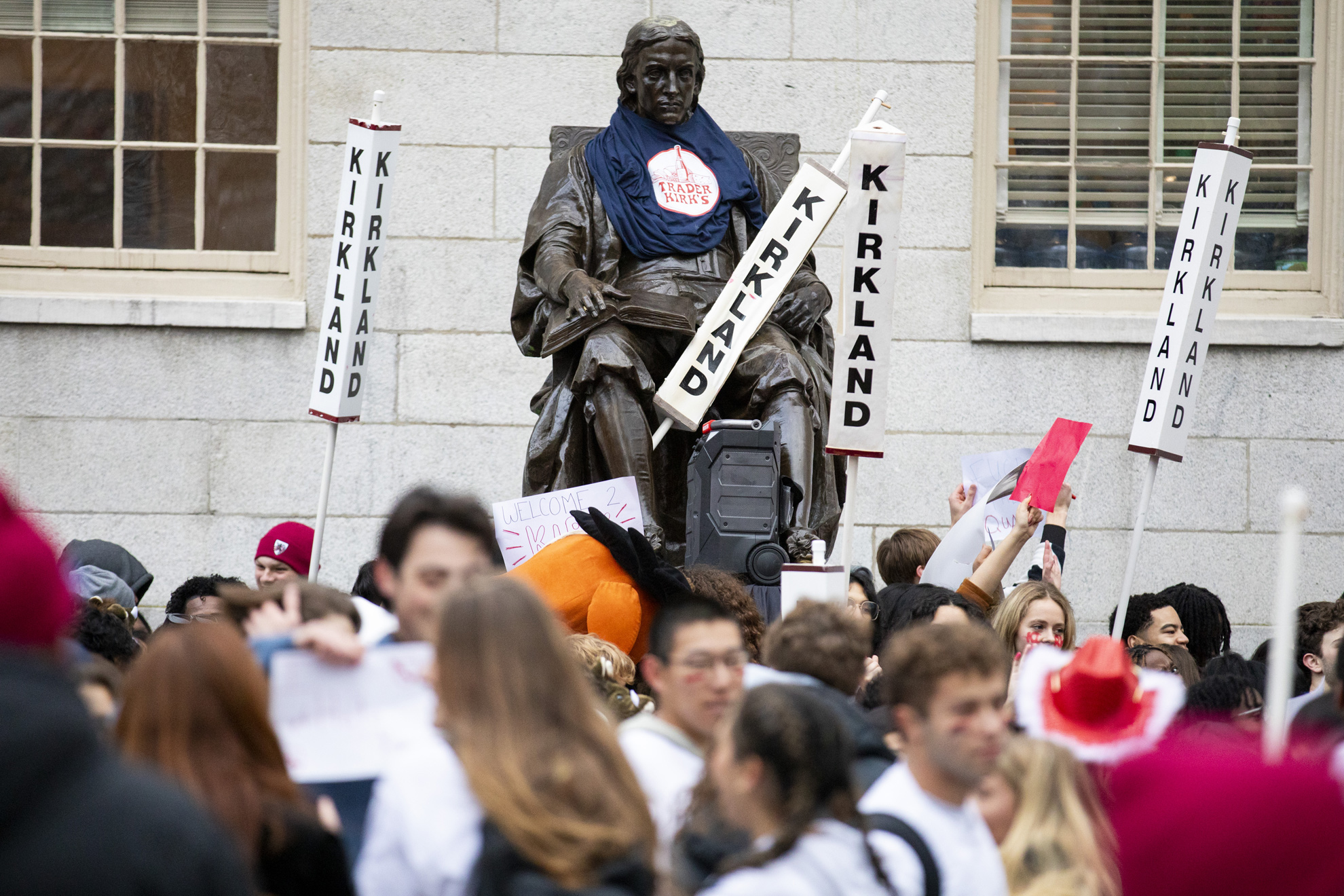 The John Harvard statue, surrounded by Kirkland House signs, is seen during the annual Housing Day tradition in Harvard Yard.