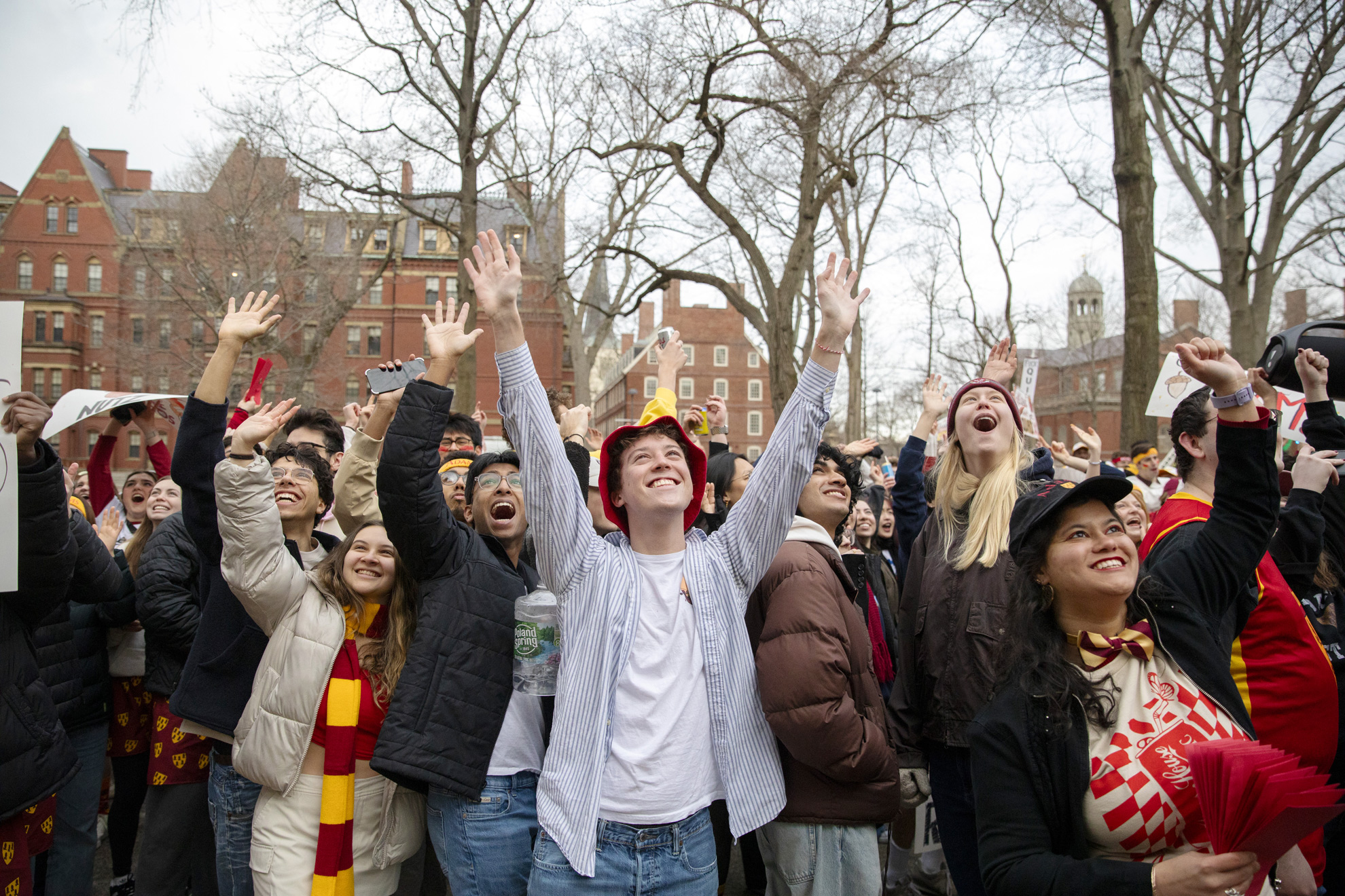 Adams House residents wave to first-years in their dorm rooms.