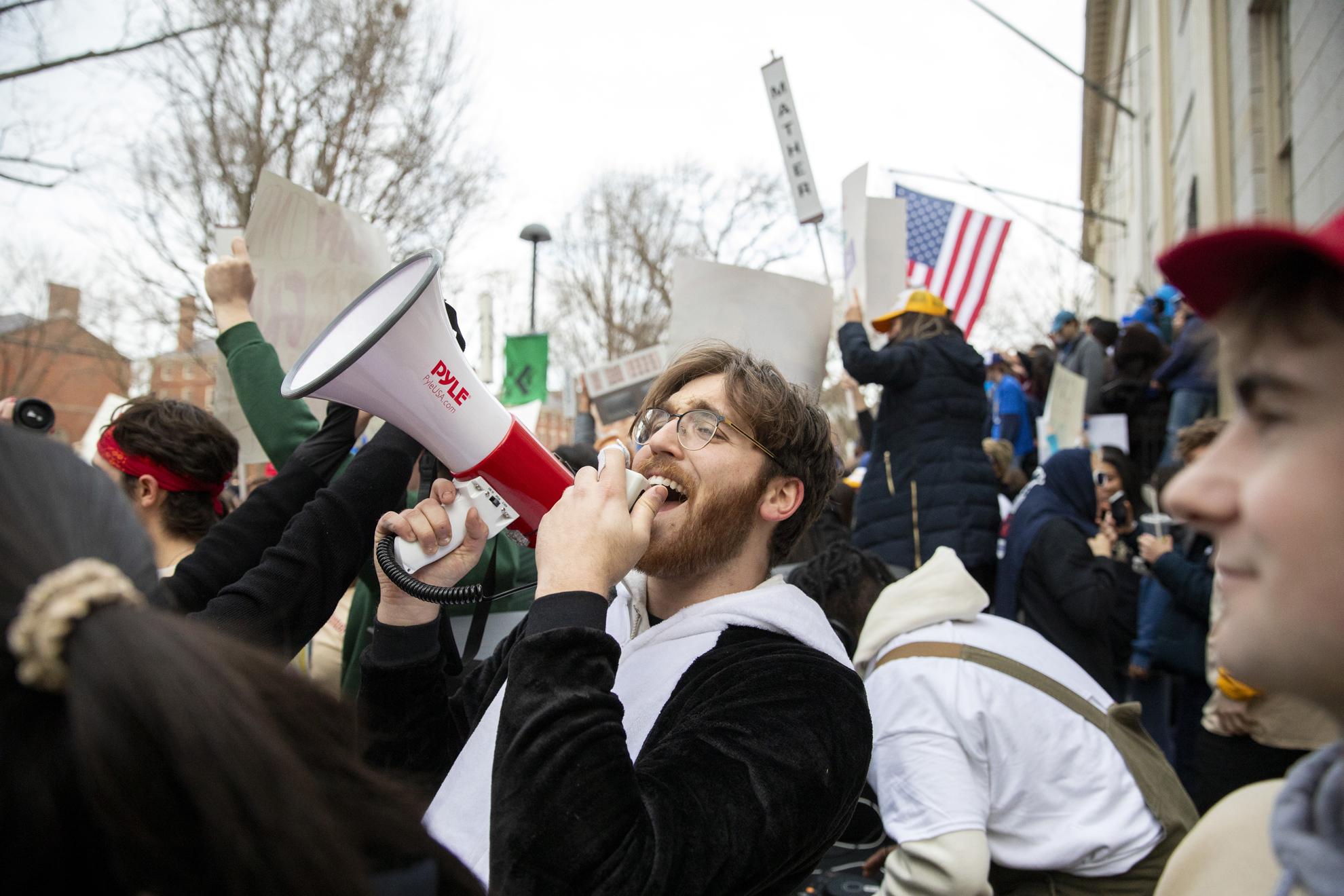 Harrison Warfel, ’26, dressed as a penguin, the mascot of Quincy House, speaks through a microphone.