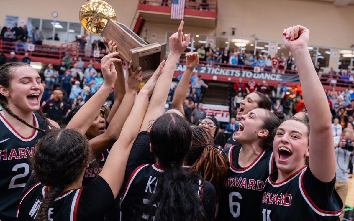 Women's basketball holds the trophy,