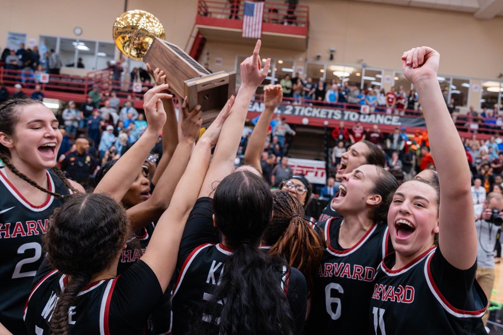 Women's basketball holds the trophy,