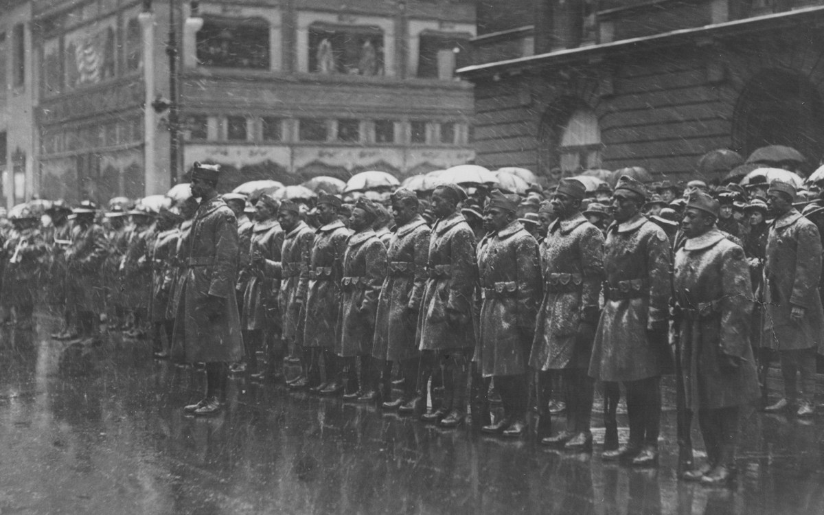 Soldiers from the Black 92nd Infantry Division line up in the rain in New York City following World War I.