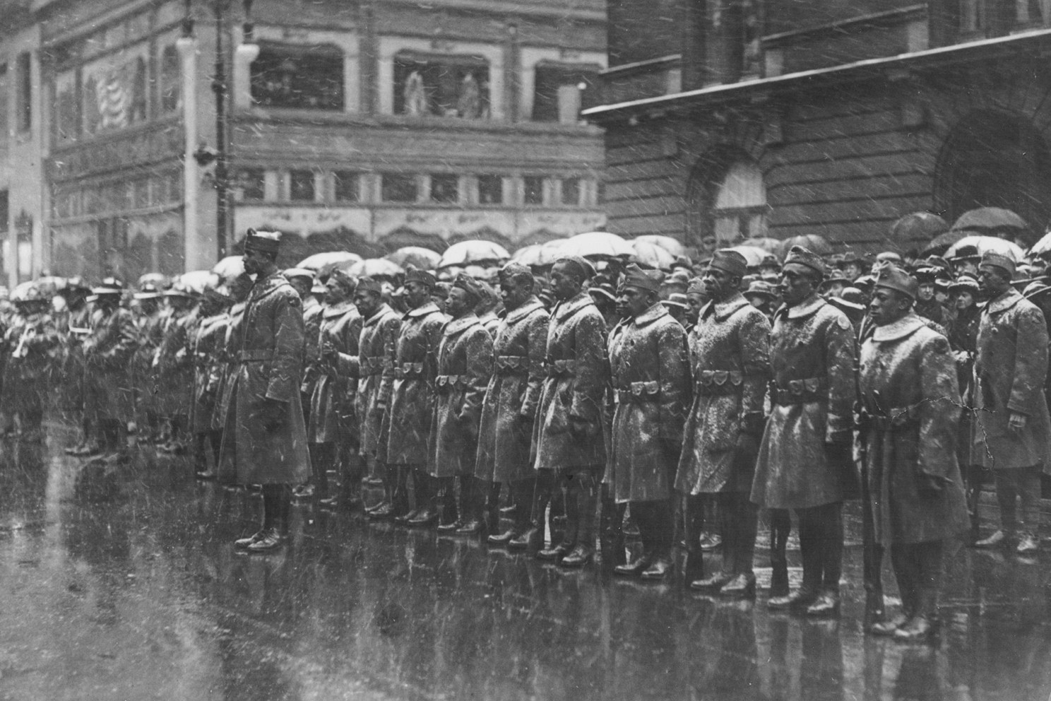 Soldiers from the Black 92nd Infantry Division line up in the rain in New York City following World War I.