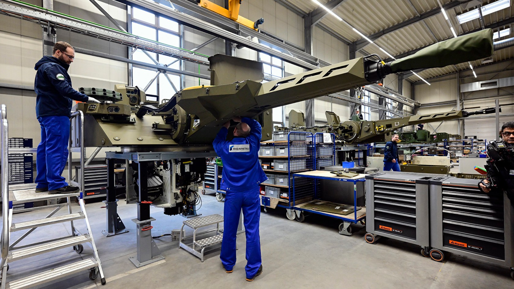 Employees at a munitions factory in Germany work on weapons in a production line.