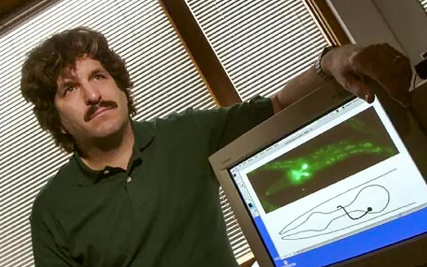 Gary Ruvkun, circa 2000, next to a computer screen showing the roundworm C. elegans.