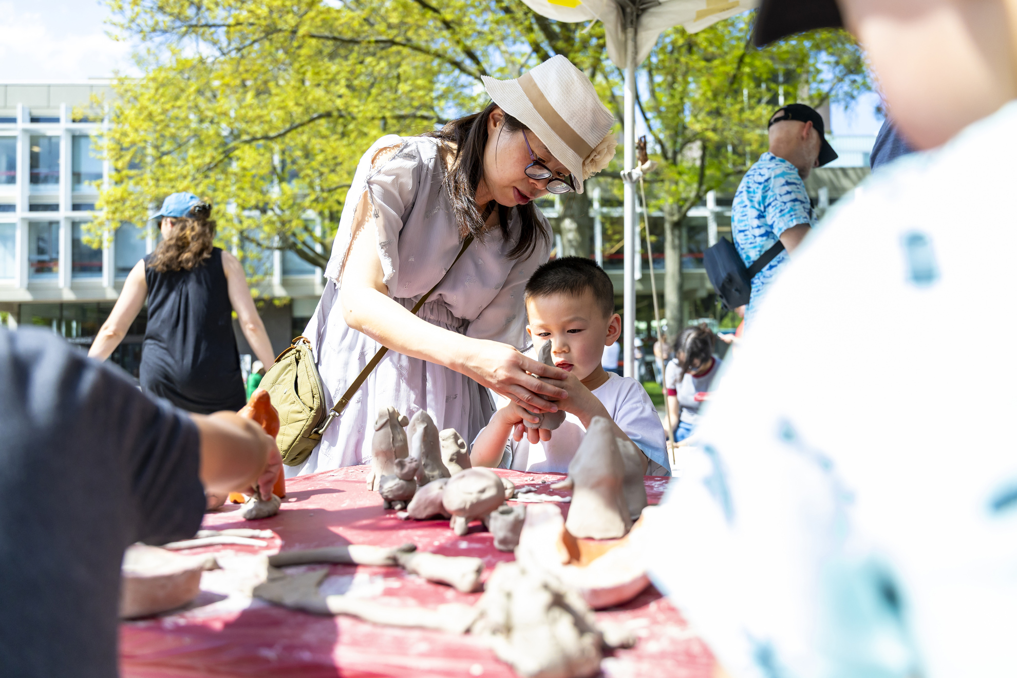 Zack Li and his mother Linghui Li mold clay in the Science Center Plaza.
