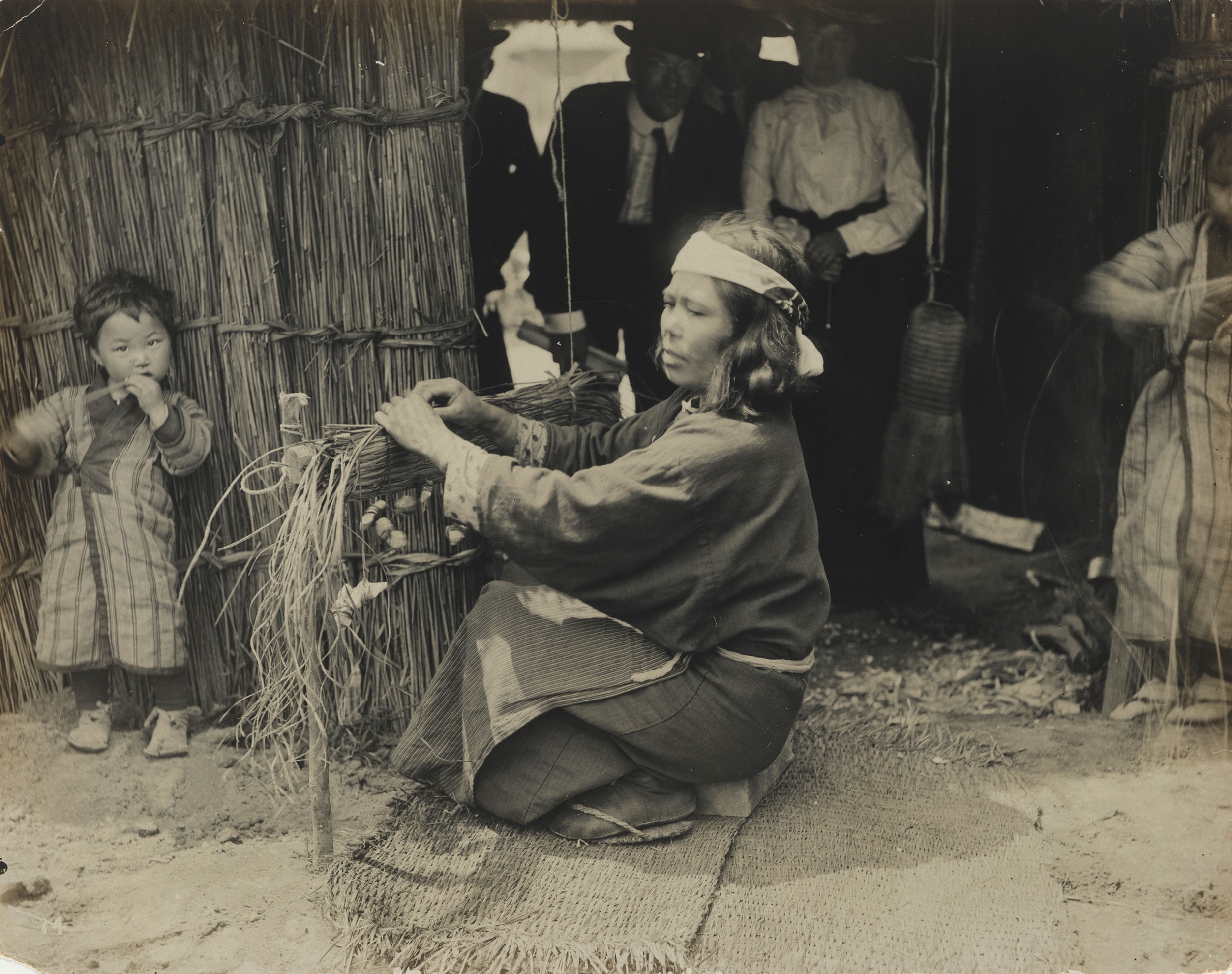 A black-and-white photograph of a woman and children in a "living exhibit" at the 1904 St. Louis World's Fair
