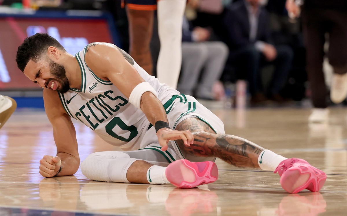 Jayson Tatum of the Boston Celtics clutches his leg on the court after injury during playoffs game vs. the New York Knicks.