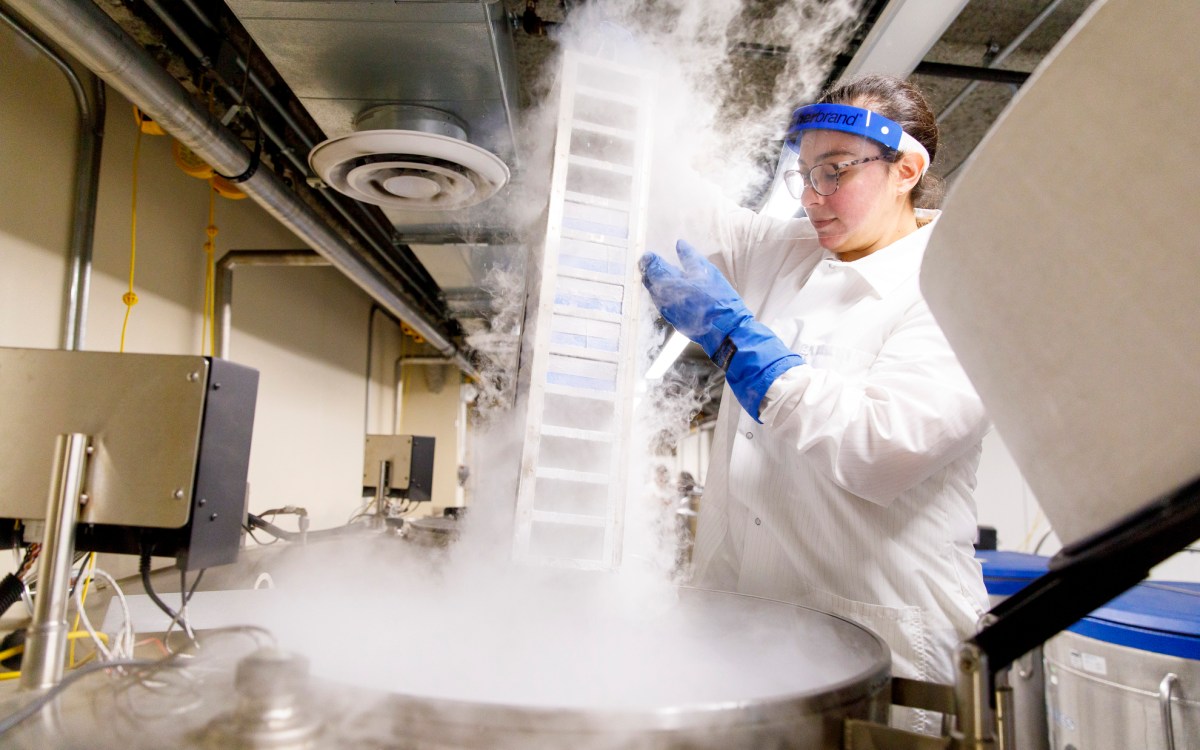 Researcher removes biological samples from freezer.