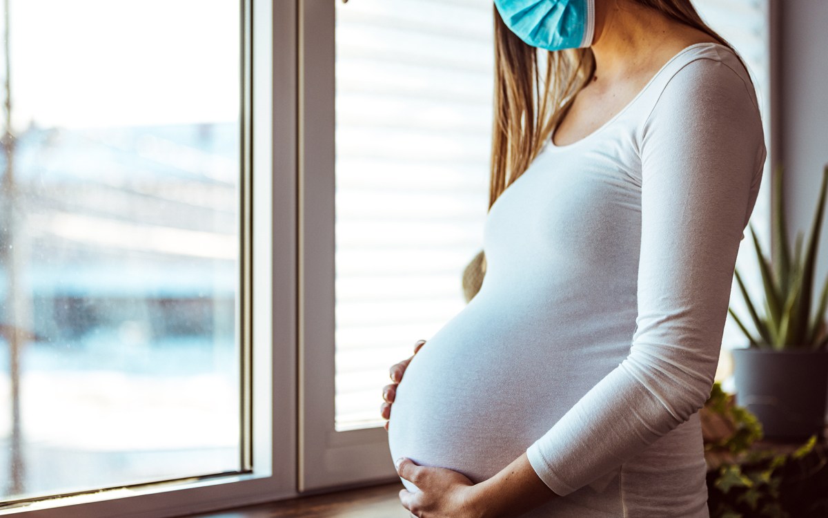 Pregnant woman wearing medical mask.