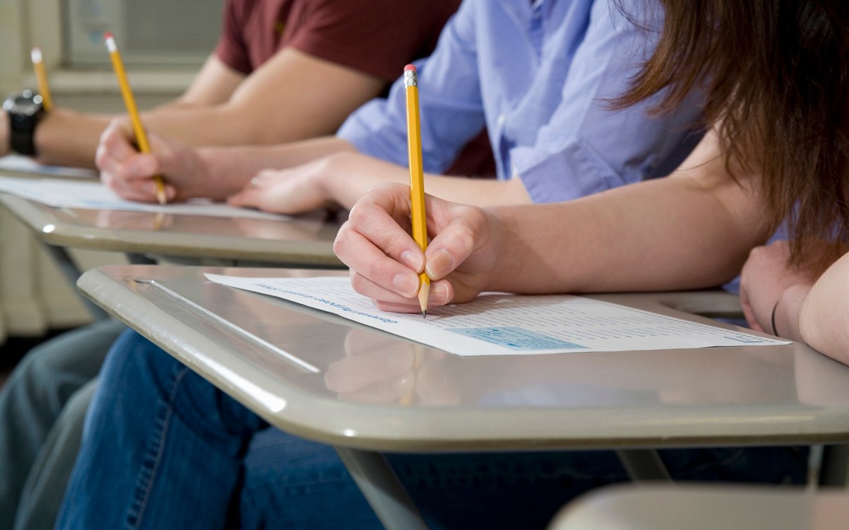 Grade-school students taking exams at their desks.