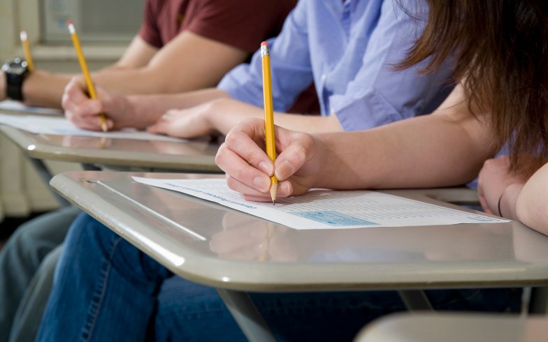 Grade-school students taking exams at their desks.