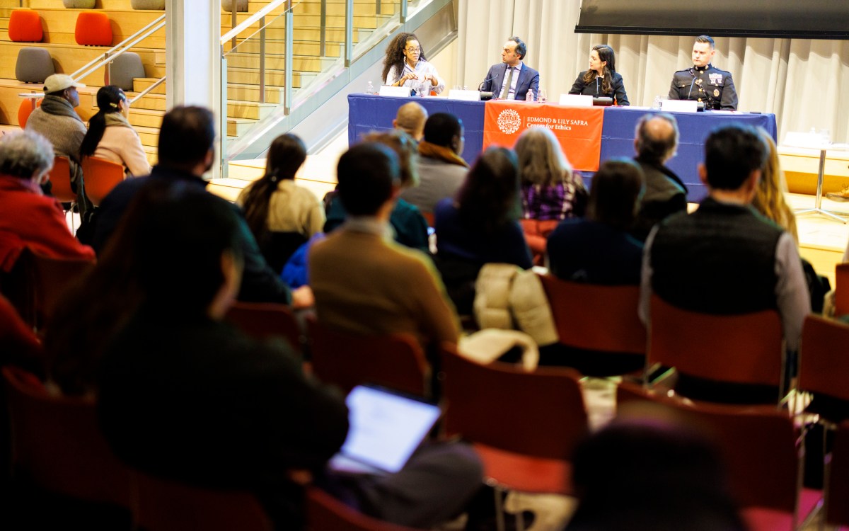 Panelists sit in front of an audience.