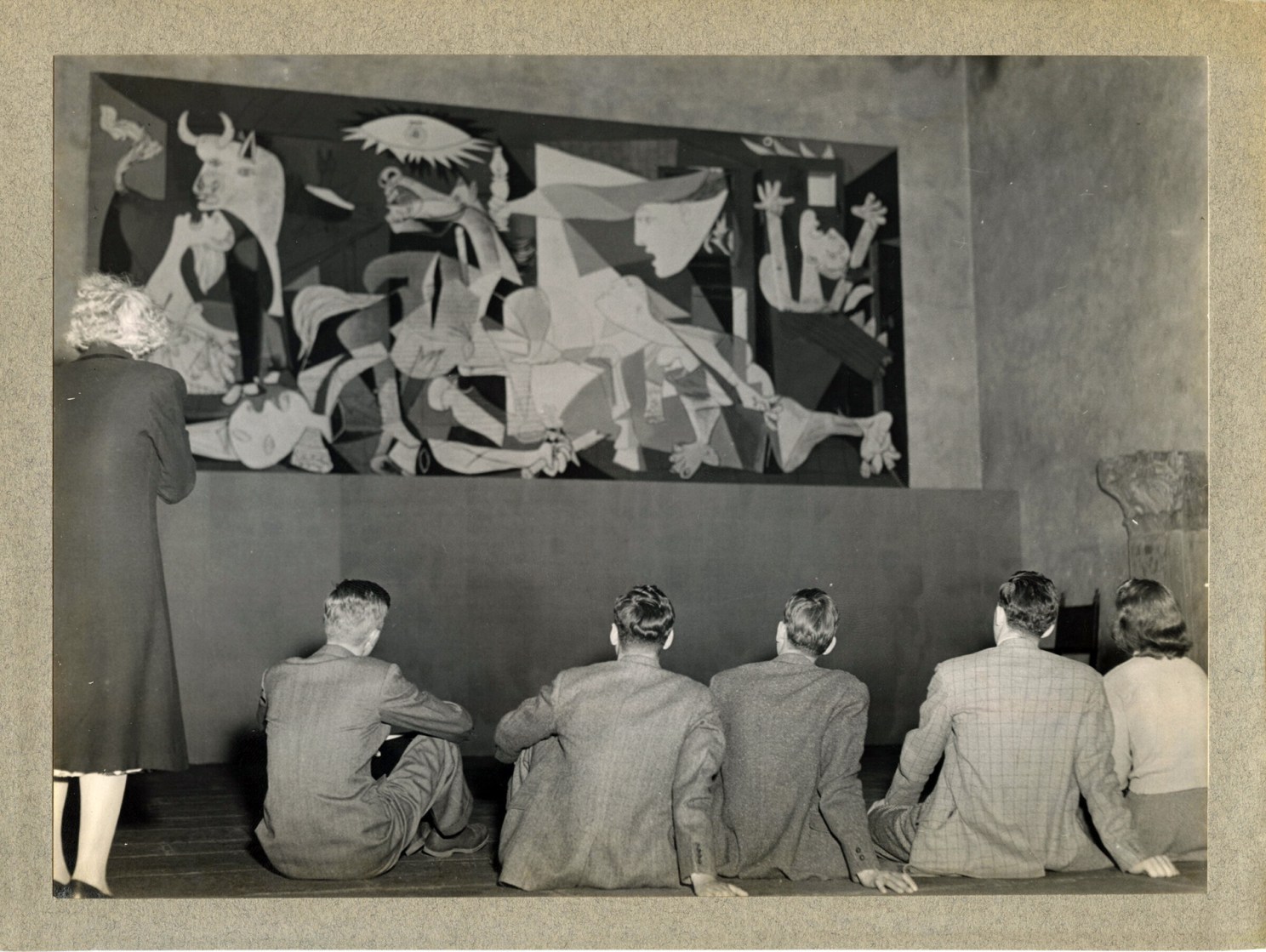 Seated students view Pablo Picasso’s “Guernica.”