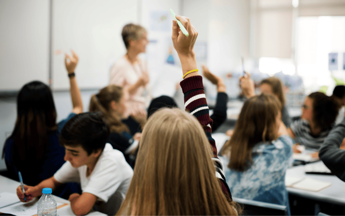 girl raising her hand in a classroom