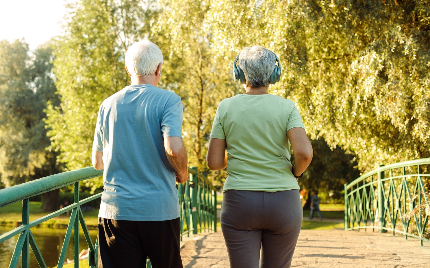 Older adults walk briskly in the park.