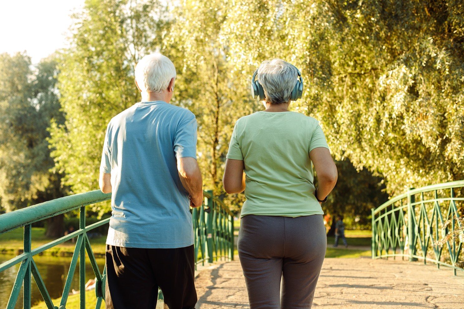 Older adults walk briskly in the park.