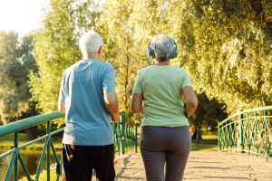 Older adults walk briskly in the park.