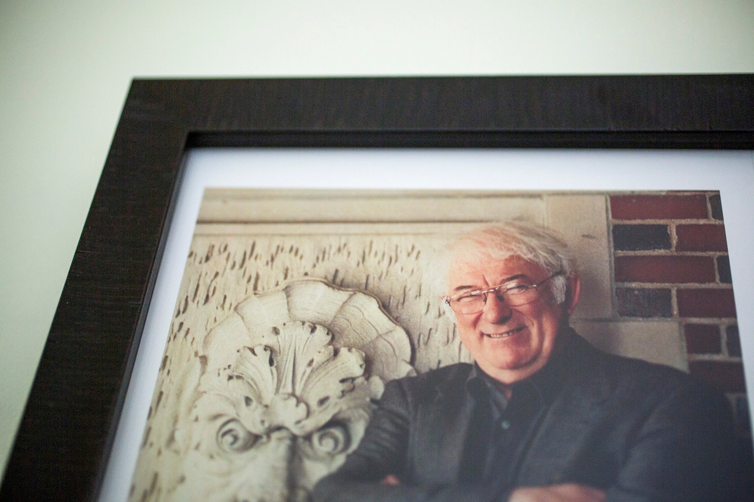 Detail of framed photo of Seamus Heaney hanging on wall of Adams House suite named after him.