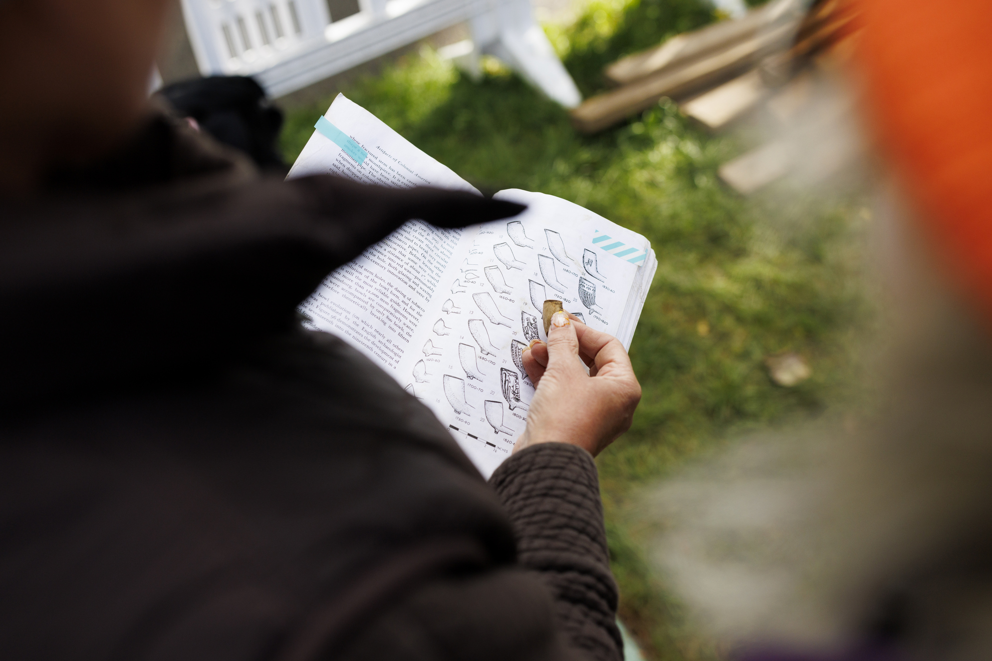 Diana Loren, the deputy director for curatorial affairs and a senior curator at the Peabody Museum, examines a fragment of a tobacco pipe discovered.