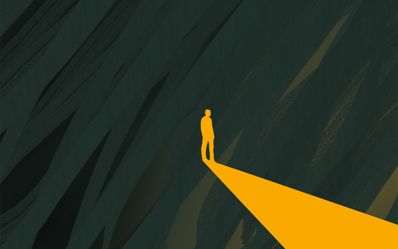 person in the dark walking towards the light