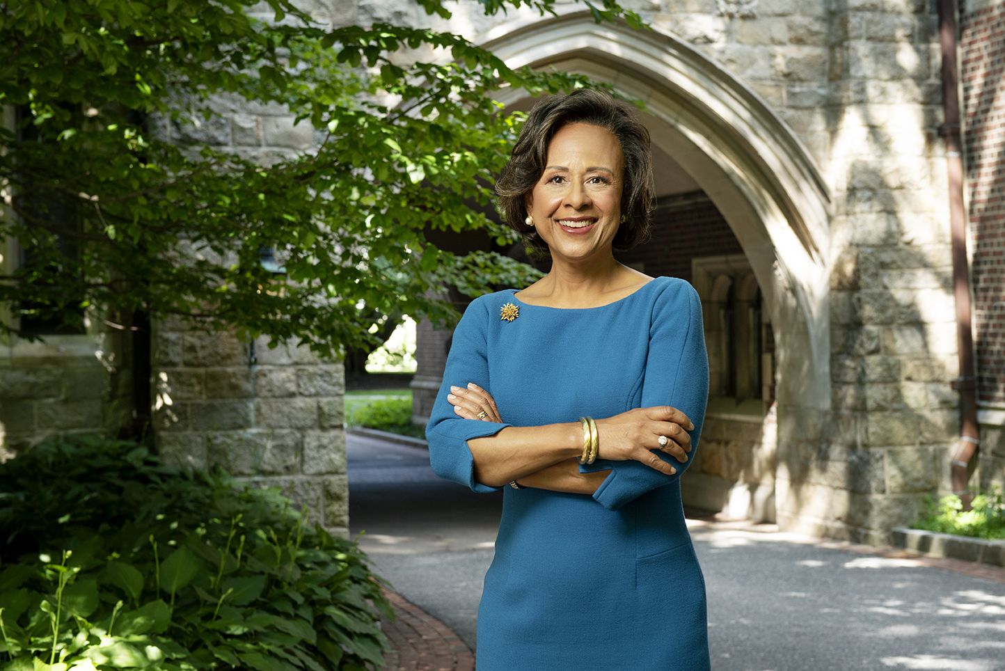 A woman stands outside with her arms crossed