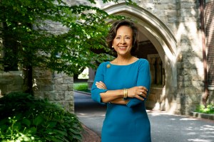 A woman stands outside with her arms crossed