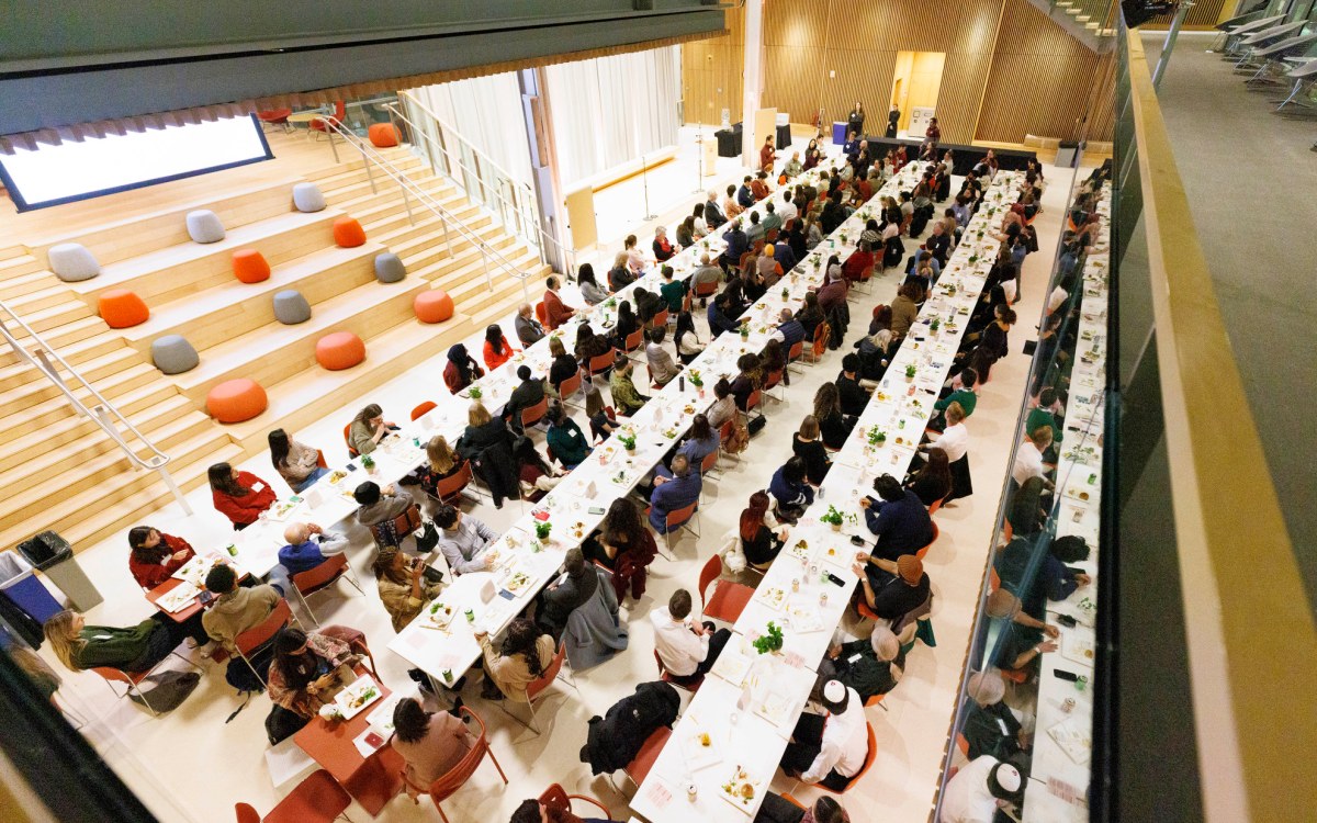 People of different faiths seated at long tables to share a meal in the campus center.