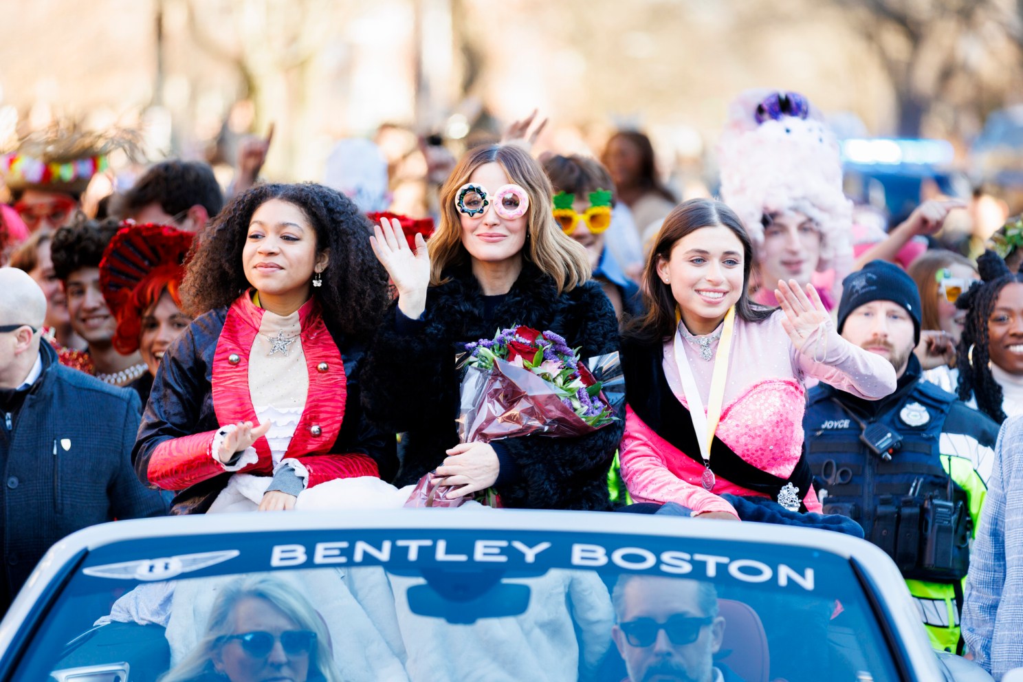 Rose Byrne donning "donut glasses" as she rides in a car with Hasty PUdding players.