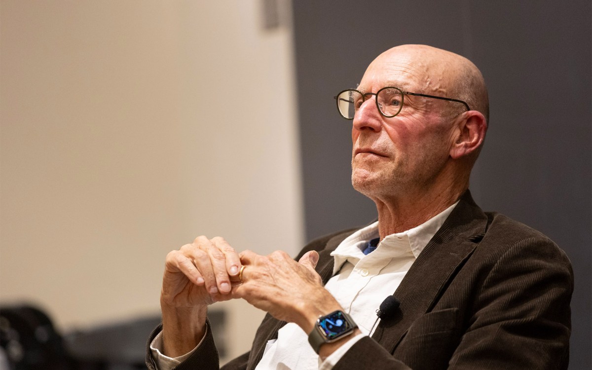 Michael Pollan sitting in a chair and listening.