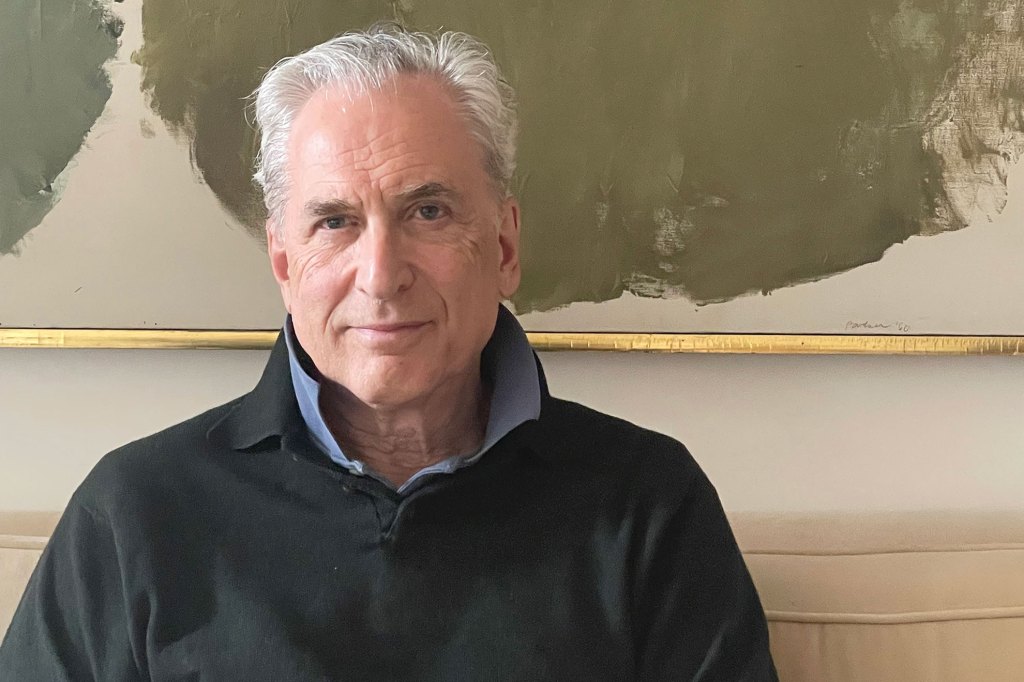 James Traub sitting for portrait with hands folded on lap.