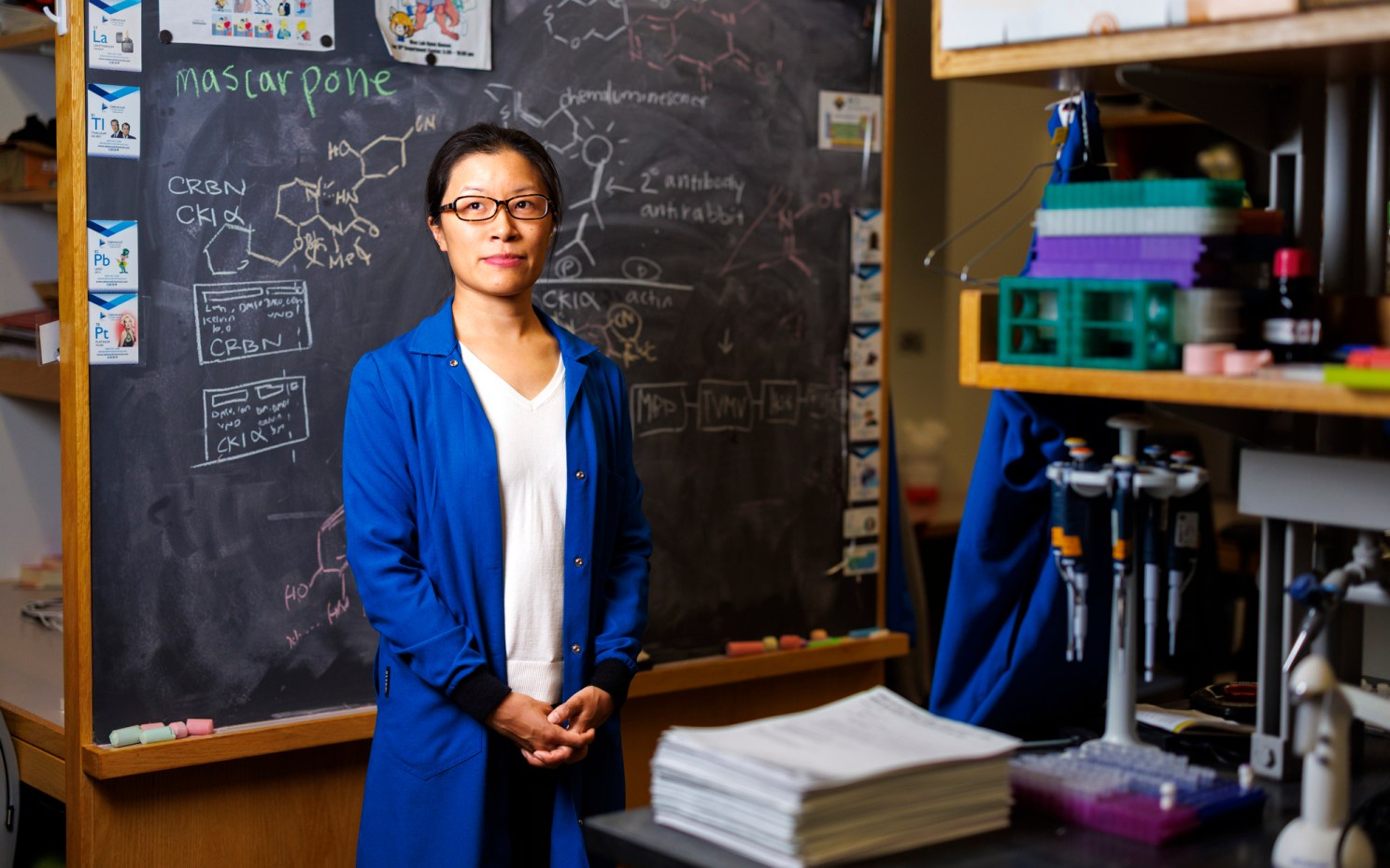 Christina Woo standing in front of a chalkboard.