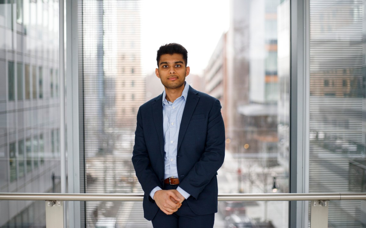 Vishal Patel standing in front of a large window.
